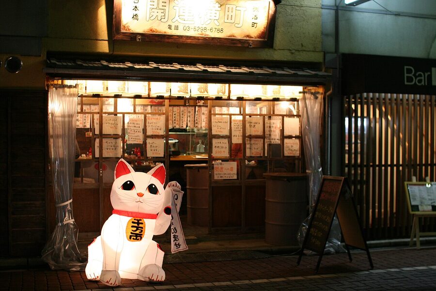 Maneki neko cat statue at the entrance of a Tokyo tachinomi standing bar